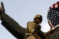 Le 9 avril 2003, un soldat américain couvre une statue de Saddam Hussein. REUTERS