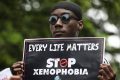 A demonstrator holds a sign during a protest against xenophobia outside of the main gate of the South African High Commission which was shut down to avert reprisal attacks in Abuja, on September 5, 2019.   South Africa said on September 5, 2019 it had temporarily closed its diplomatic missions in Nigeria following violence against South African businesses carried out in reprisal for attacks on foreign-owned stores in Johannesburg. / AFP / KOLA SULAIMON